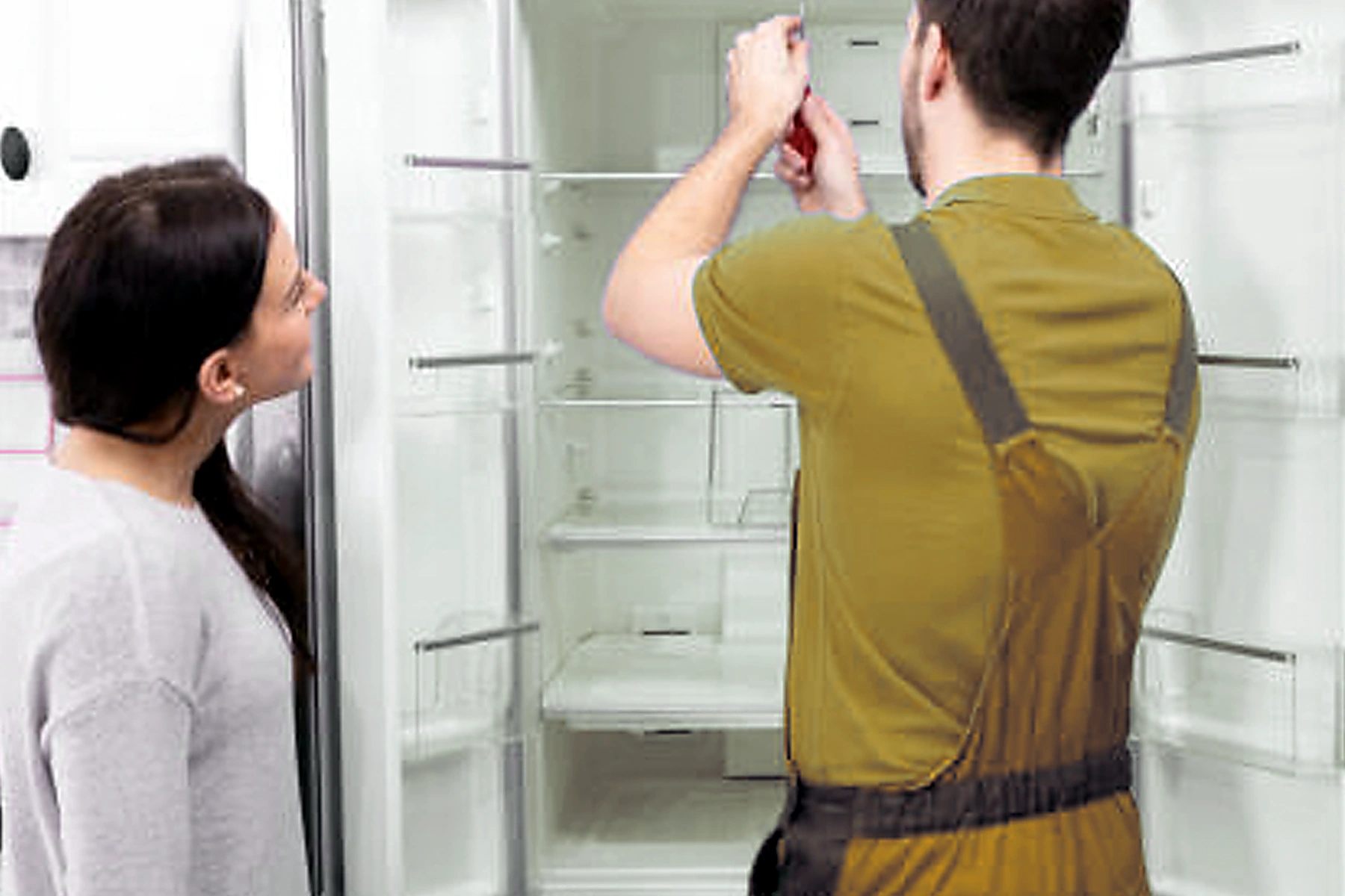 Illustrative appliance technician examining a refrigerator
